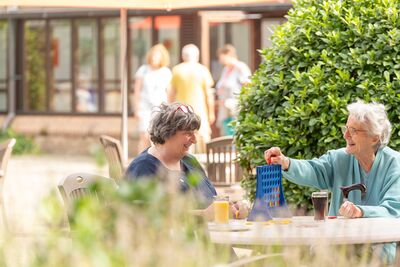 Drie vrouwen waarvan twee in rolstoel vakantie aan het vieren in de natuurrijke omgeving van de Zorgverblijven