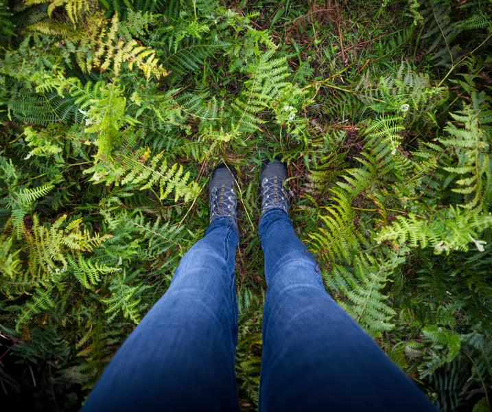 Vrouw staat met beide voeten op de grond in het bos. Campagnebeeld Arbeidsongeschikt.