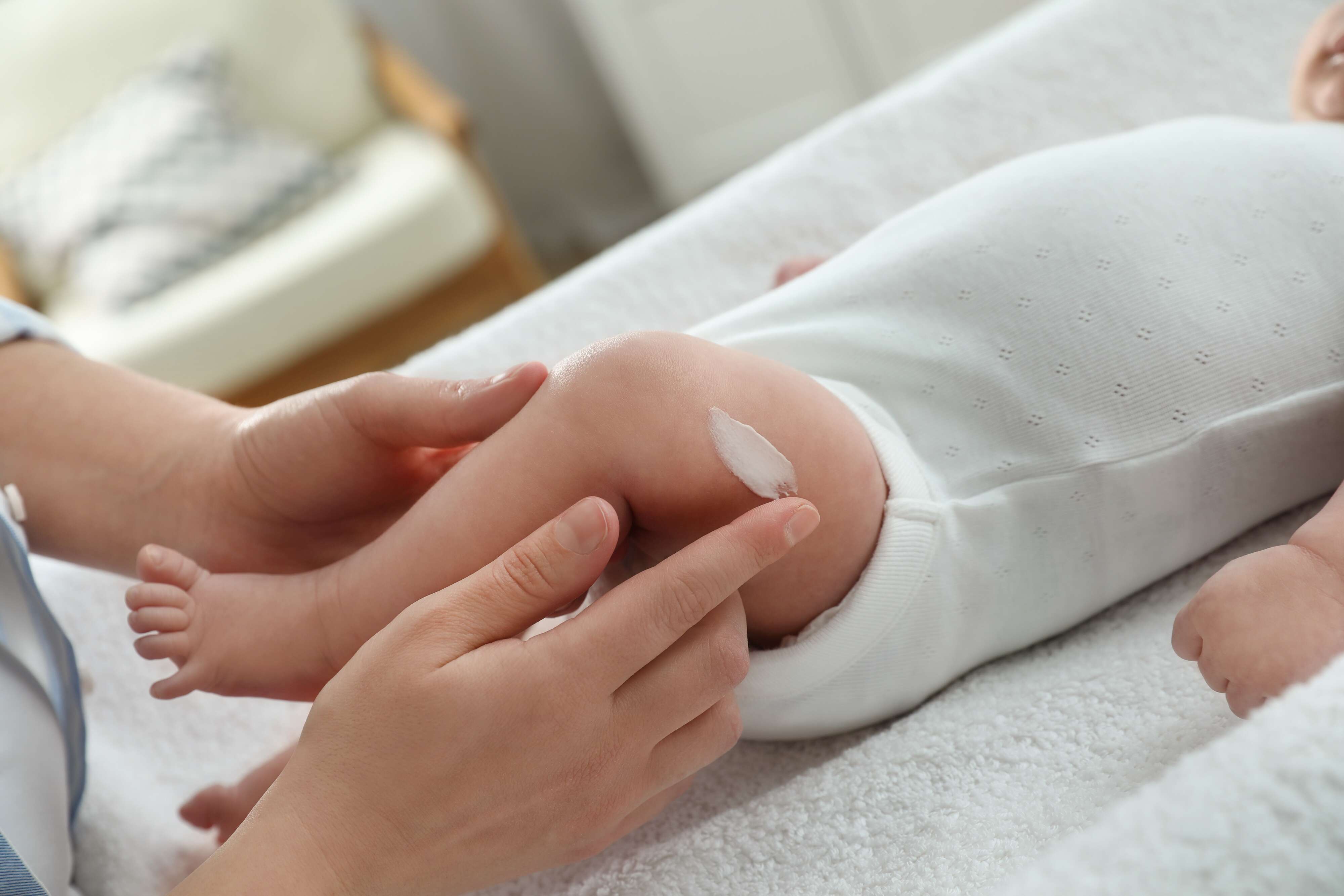babybeentje wordt ingesmeerd voor massage